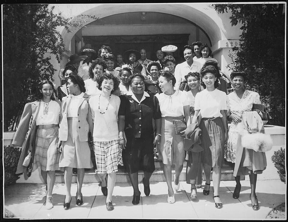 "Hattie McDaniel (center), Chairman of the Negro Division of the Hollywood Victory Committee, takes time off from rehearsals...to lead a caravan of entertainers and hostesses to Minter Field,...for a